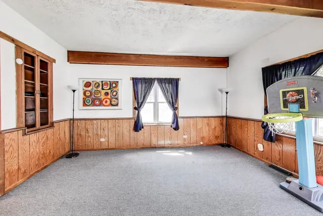 an empty room with windows & cabinet