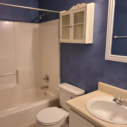 a white toilet sitting next to a bathroom sink