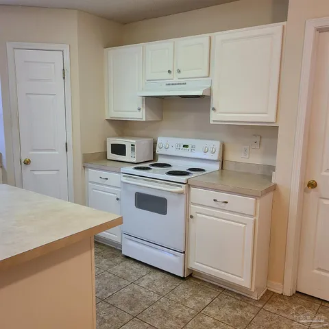 a kitchen with white cabinets and white appliances