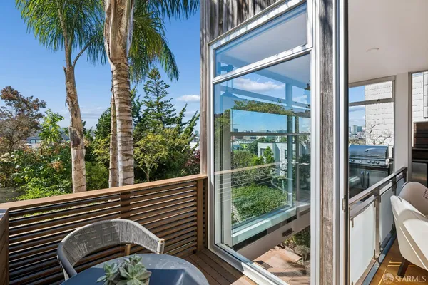 a view of a balcony with a floor to ceiling window and wooden fence