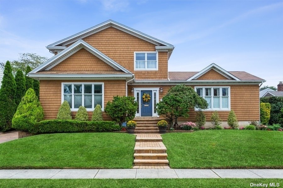 215 Roxbury Road Garden City, NY 11530 - Photo 1 of 1 a front view of a house with a yard and potted plants