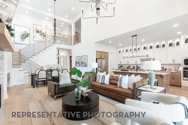 a living room with furniture kitchen view and a chandelier