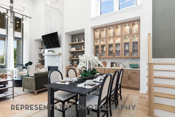 a view of a dining room with furniture a fireplace and wooden floor