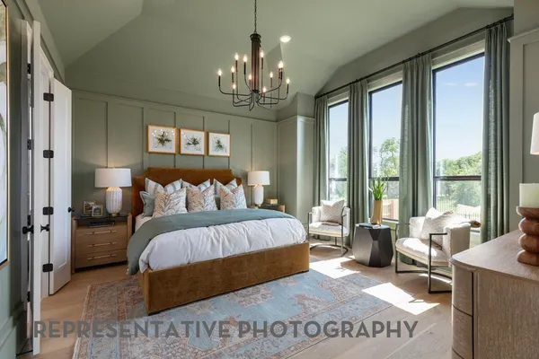 a bedroom with a large bed and a chandelier