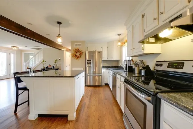 a kitchen with stainless steel appliances granite countertop a stove a sink and a refrigerator