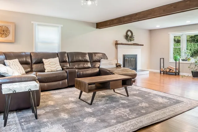 a living room with furniture a fireplace and wooden floor