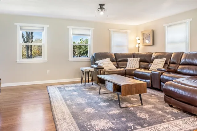 a living room with furniture a rug and a window