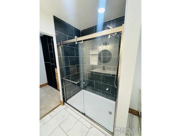 a bathroom with a glass shower door and a window