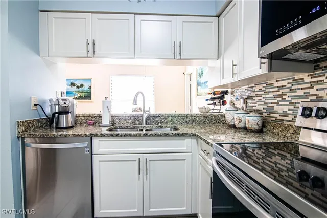 a kitchen with stainless steel appliances granite countertop a sink stove and cabinets