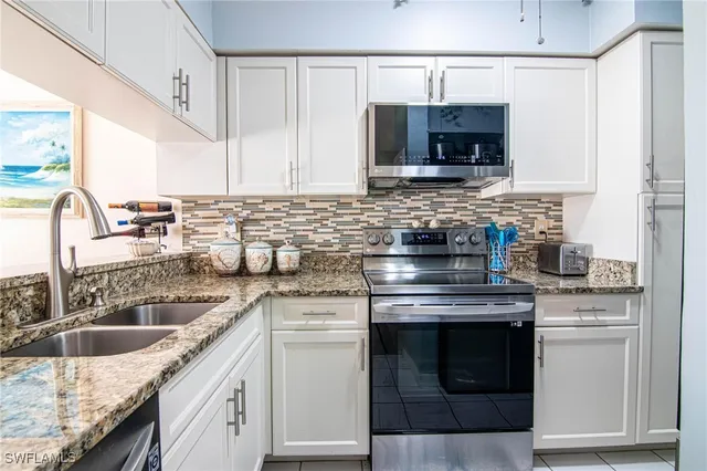 a kitchen with granite countertop a sink stove and cabinets