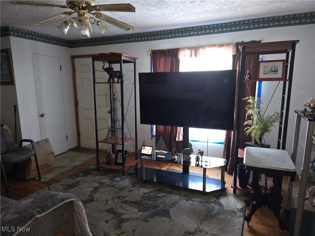 1516 Scenic Way Akron, OH 44310 - Photo 7 of 10 Living area featuring a ceiling fan, a textured ceiling, and wood finished floors