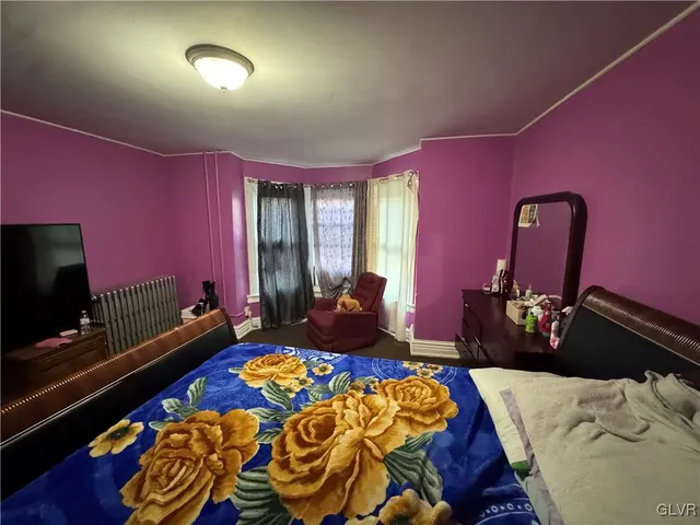 a bedroom with a bed and dresser with mirror