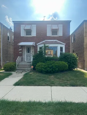 a view of a brick house next to a yard