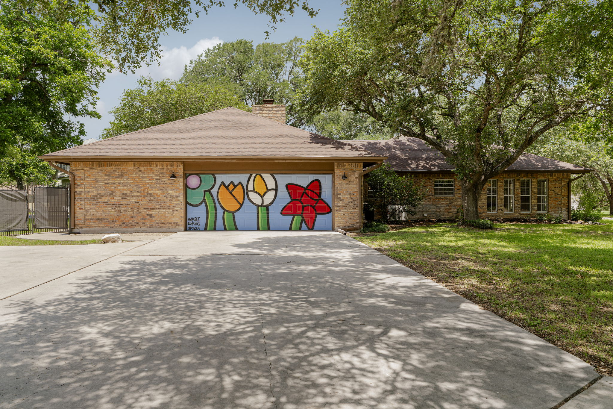 400 Hackberry Street Lockhart, TX 78644 - Photo 32 of 40 Artistic flair meets practicality on this home's garage, nestled within a verdant setting.