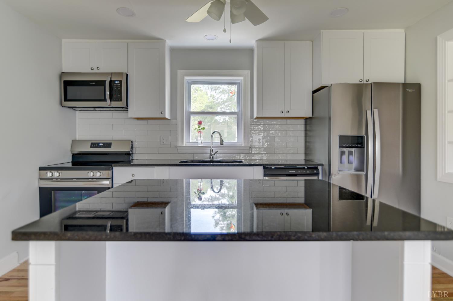 4724 Old Boonsboro Road Lynchburg, VA 24503 - Photo 8 of 39 a kitchen with kitchen island granite countertop stainless steel appliances a sink stove refrigerator and cabinets