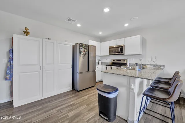 a kitchen with a refrigerator and a stove top oven