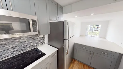 a kitchen with granite countertop a refrigerator and a stove top oven
