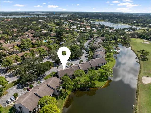 an aerial view of residential houses with outdoor space and lake view
