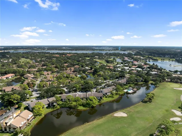 an aerial view of residential houses with outdoor space and lake view