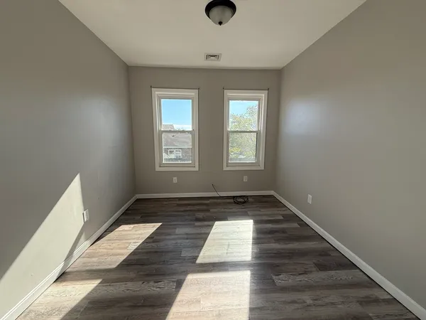 a view of a room with wooden floor and window
