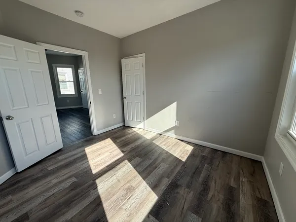 a view of a bedroom with wooden floor and stairs