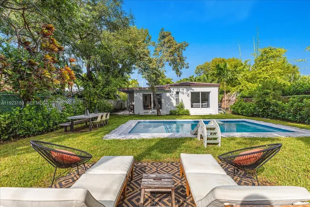 a view of a house with swimming pool and sitting area