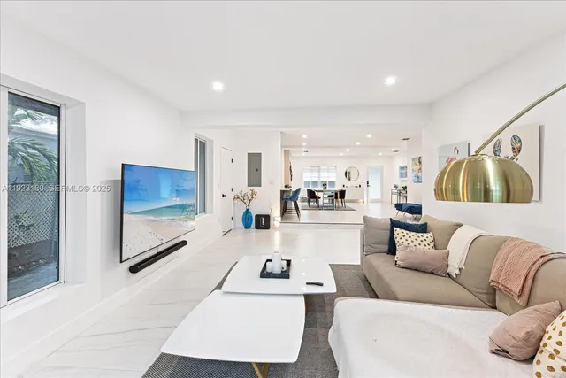 a living room with furniture and a view of kitchen