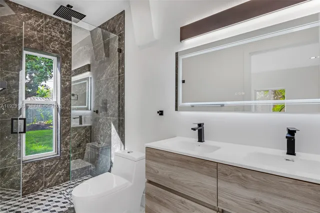 a bathroom with a sink a toilet and a shower