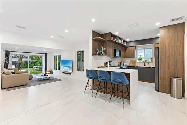 a living room with stainless steel appliances kitchen island granite countertop furniture and a large window