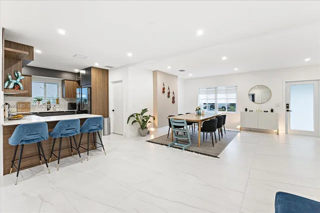 a living room with furniture and a dining table with kitchen view