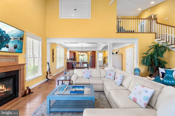 a large kitchen with stainless steel appliances kitchen island granite countertop a refrigerator a sink a stove with white cabinets and wooden floor