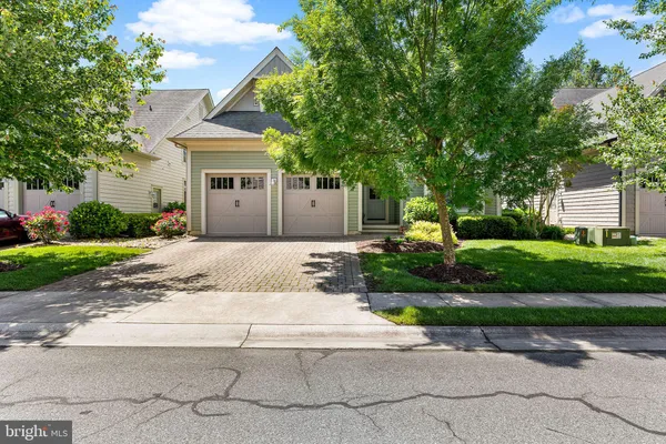 a front view of a house with garden and plants