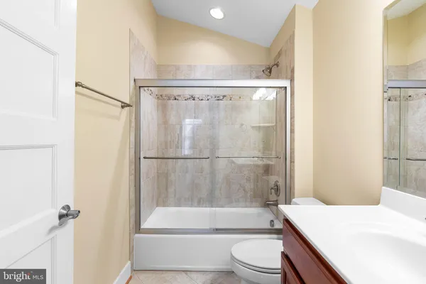 a living room with couch a dining table and paintings on the wall