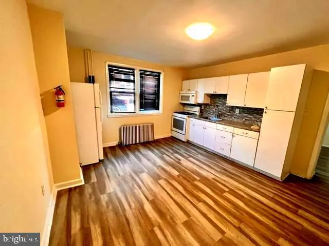 a kitchen with a refrigerator a stove top oven and sink