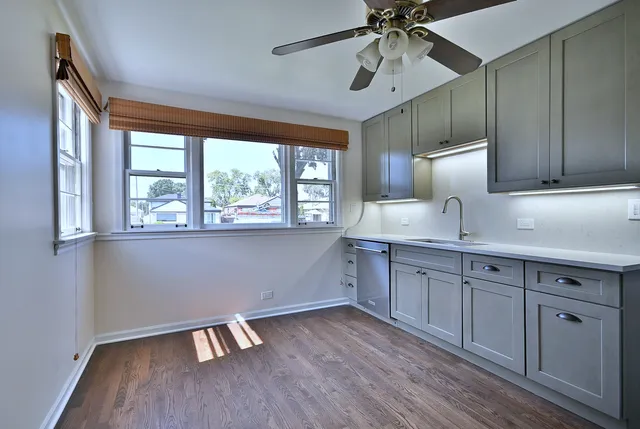 a kitchen with wooden floors and windows
