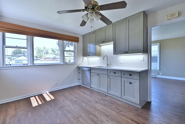 a kitchen with a sink cabinets and wooden floor