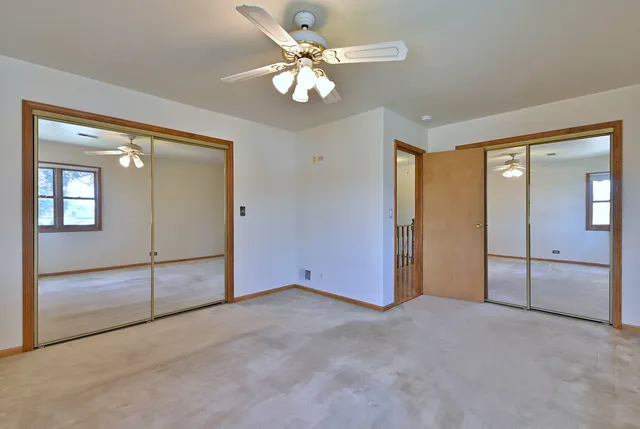 an empty room with fan and entrance