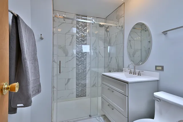 a bathroom with a sink a toilet and shower