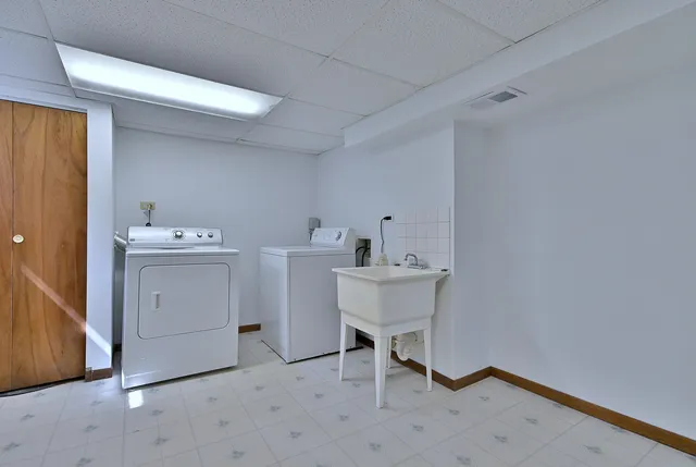 a utility room with cabinets washer and dryer