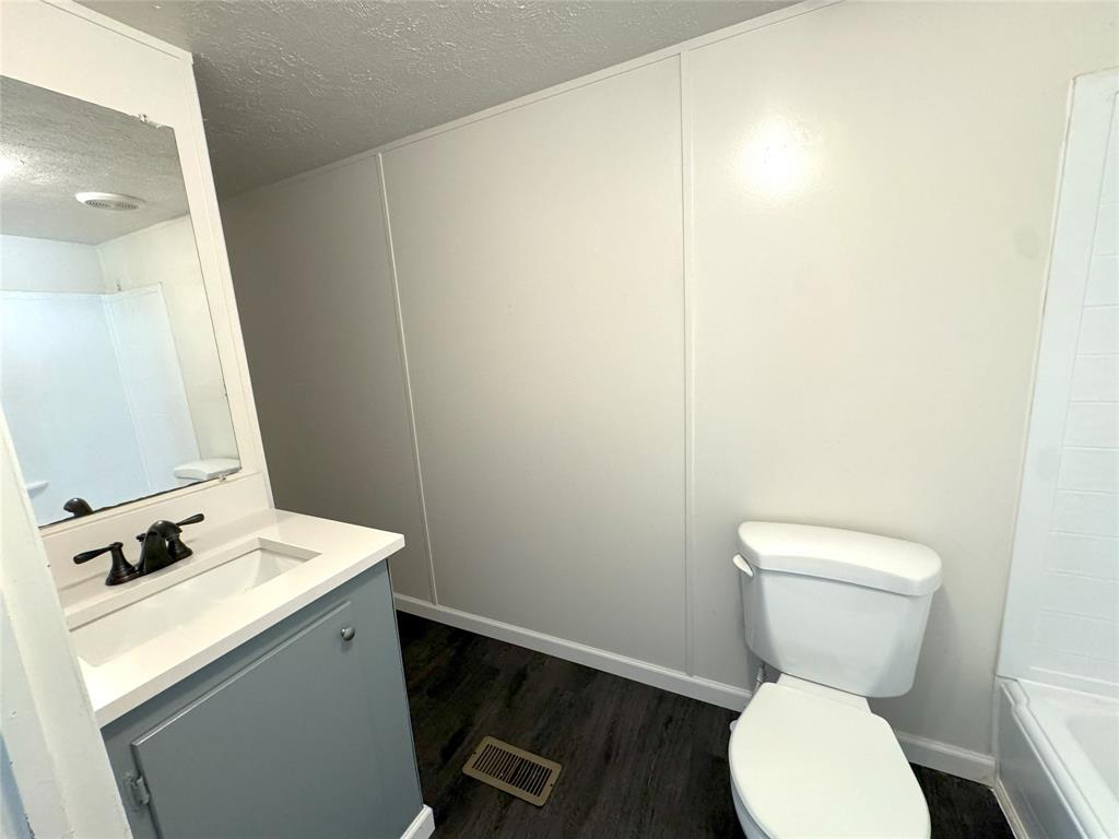 2087 Meadow Road Kerens, TX 75144 - Photo 12 of 28 a bathroom with a toilet a sink and a mirror