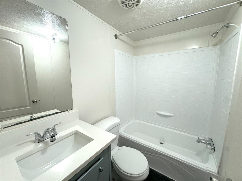 2087 Meadow Road Kerens, TX 75144 - Photo 16 of 28 a bathroom with a sink mirror toilet and bathtub