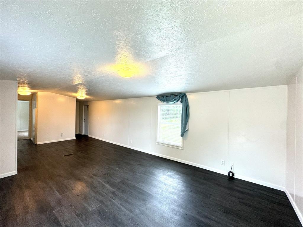 2087 Meadow Road Kerens, TX 75144 - Photo 5 of 28 a view of an empty room with wooden floor and a window