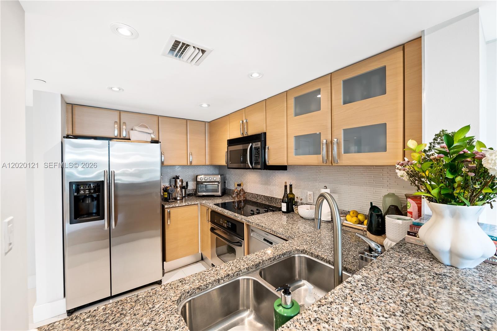 2101 Brickell Avenue, Unit 1909 Miami, FL 33129 - Photo 8 of 25 a kitchen with stainless steel appliances granite countertop a refrigerator sink and stove