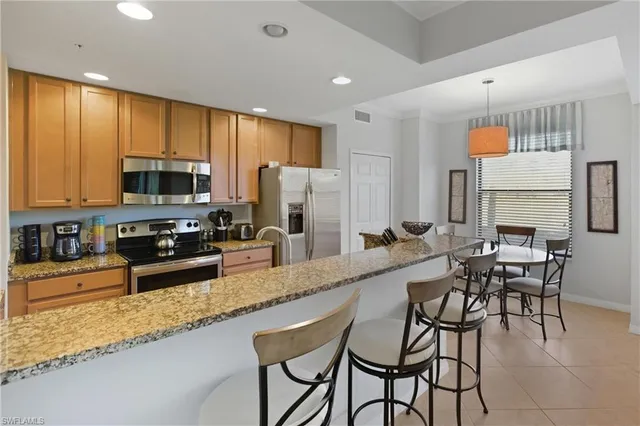 a large kitchen with granite countertop a counter space a sink appliances and cabinets
