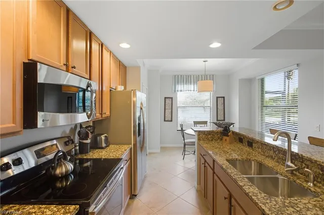 a kitchen with stainless steel appliances granite countertop a sink stove and refrigerator