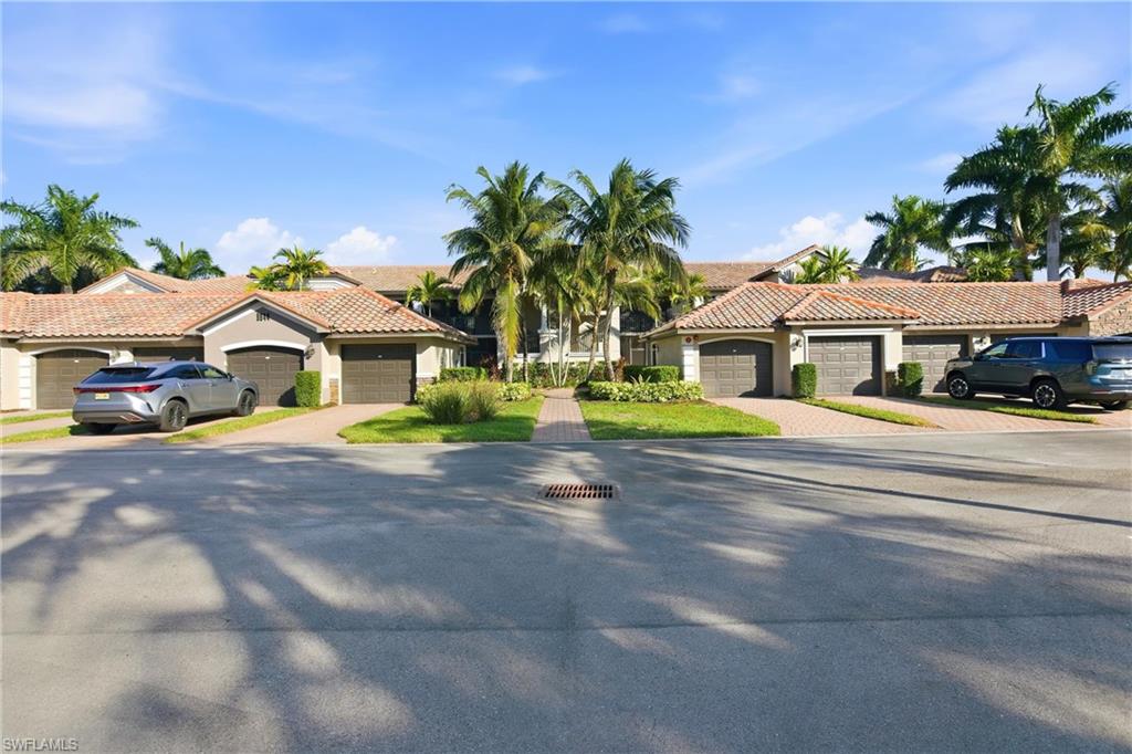 9844 Venezia Circle, Unit 714 Naples, FL 34113 - Photo 2 of 50 a front view of house with a yard and potted plants