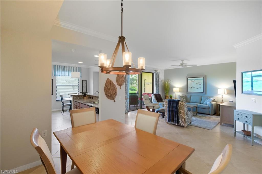 9844 Venezia Circle, Unit 714 Naples, FL 34113 - Photo 21 of 50 a living room with furniture a chandelier and a table