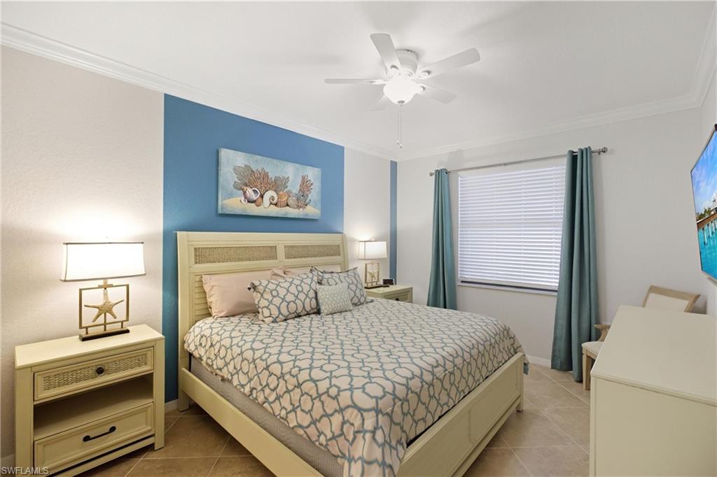 9844 Venezia Circle, Unit 714 Naples, FL 34113 - Photo 25 of 50 a bedroom with a large bed and a chandelier