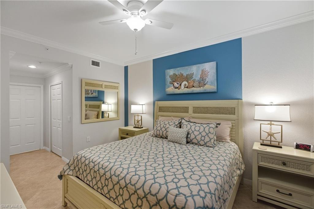 9844 Venezia Circle, Unit 714 Naples, FL 34113 - Photo 26 of 50 a bedroom with a bed and a painting on the wall