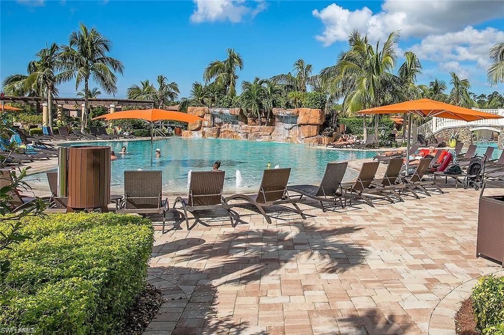9844 Venezia Circle, Unit 714 Naples, FL 34113 - Photo 41 of 50 a view of a patio with table and chairs under an umbrella
